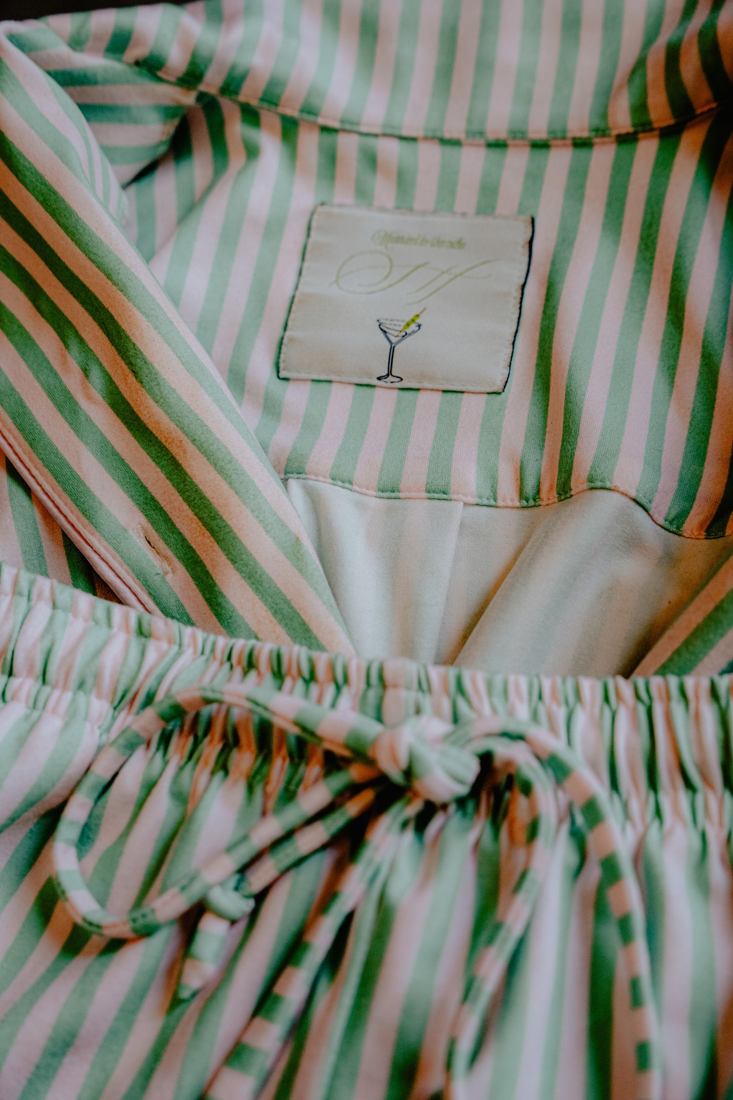 Close-up of a green and pink striped garment with a label.