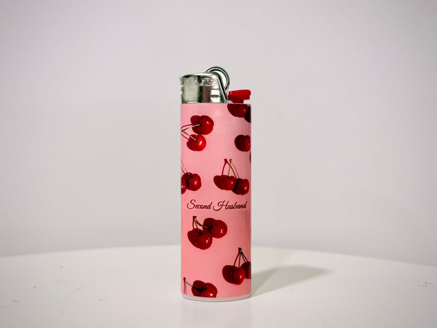 Pink lighter with cherry design on a white background