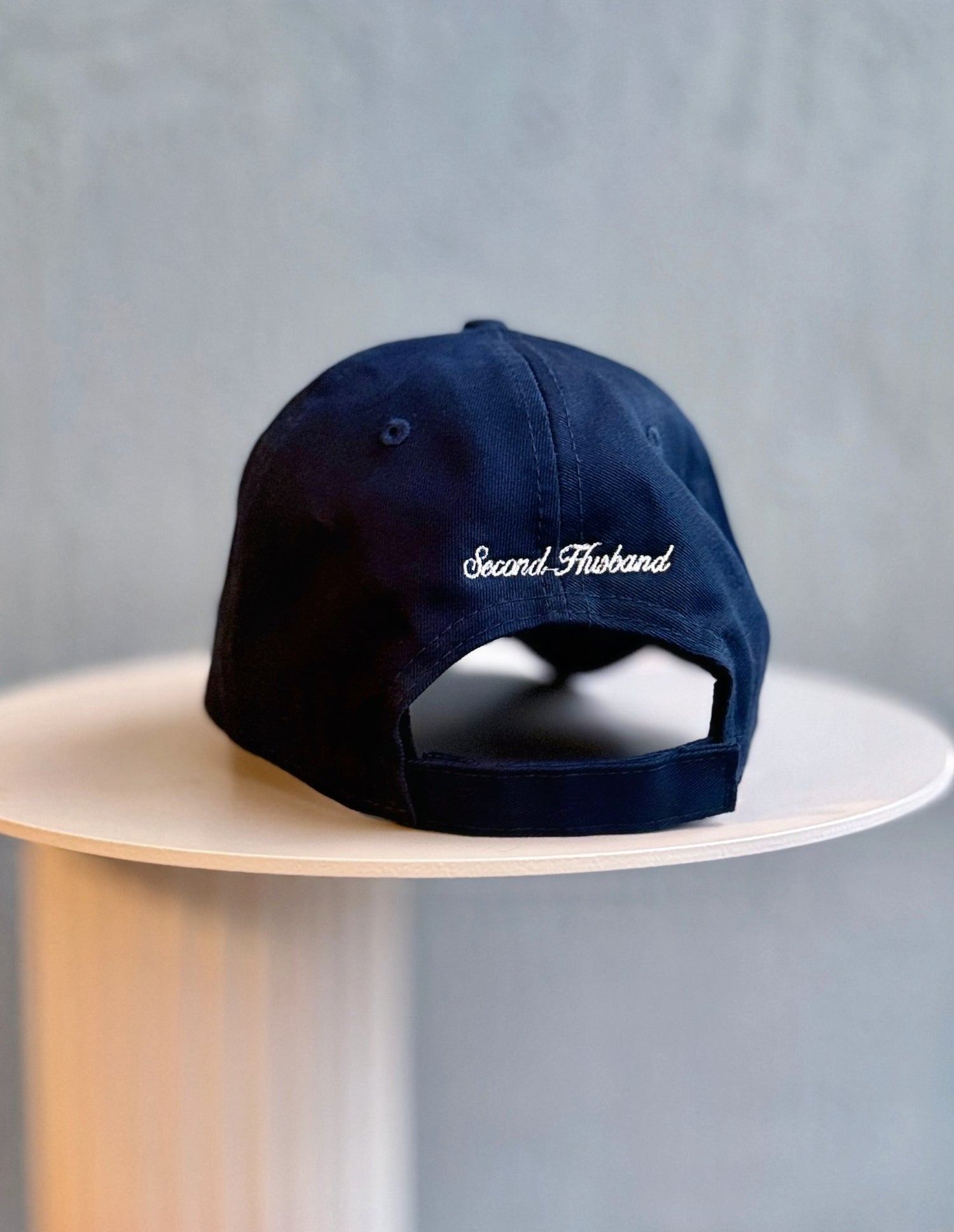 Navy blue cap with 'Second Thread' logo on a light gray background